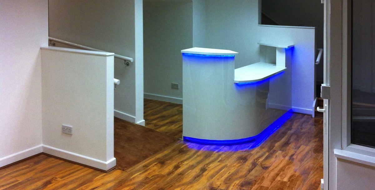 flooring and bespoke reception area up lit with blue lighting as an example of interior office fit outs in Aberdeen City